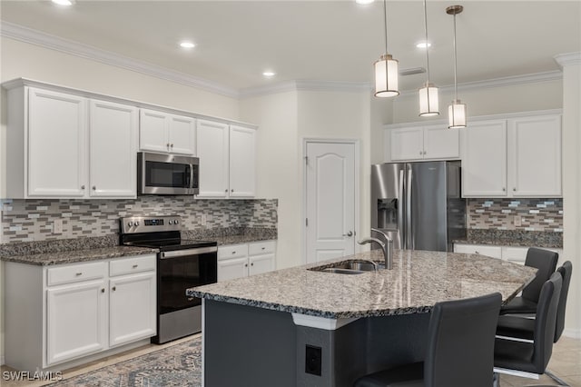 kitchen featuring sink, white cabinetry, an island with sink, pendant lighting, and stainless steel appliances