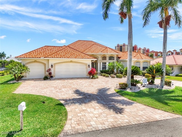 mediterranean / spanish house featuring a front yard and a garage