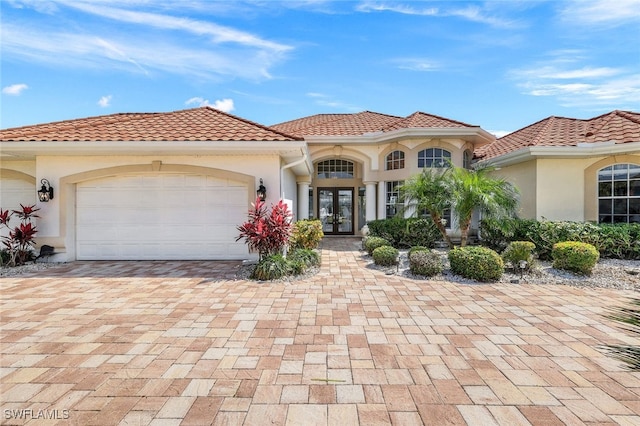 mediterranean / spanish-style home featuring french doors and a garage