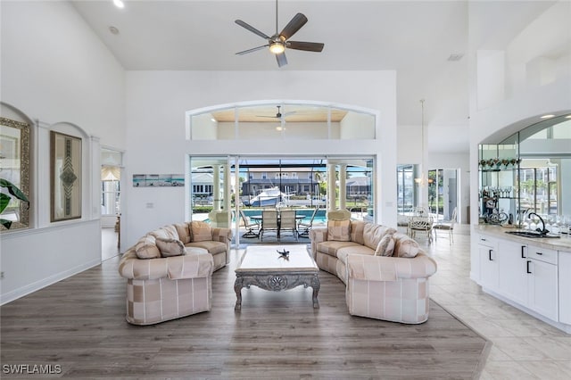 living room with sink, a high ceiling, and ceiling fan