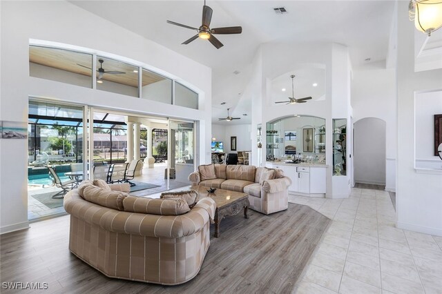 living room featuring high vaulted ceiling and light wood-type flooring