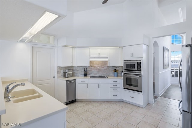 kitchen with sink, white cabinets, stainless steel appliances, and light tile patterned floors