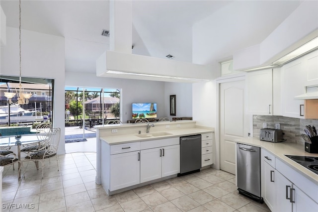 kitchen with dishwasher, kitchen peninsula, hanging light fixtures, sink, and white cabinets