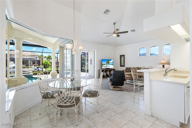 dining area with ceiling fan, decorative columns, sink, and light tile patterned floors