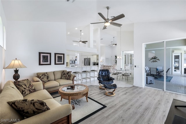 living room with light hardwood / wood-style floors and high vaulted ceiling