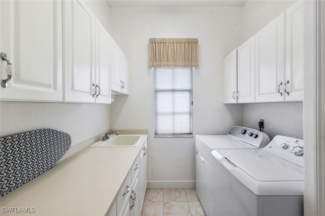 clothes washing area with sink, independent washer and dryer, light tile patterned floors, and cabinets