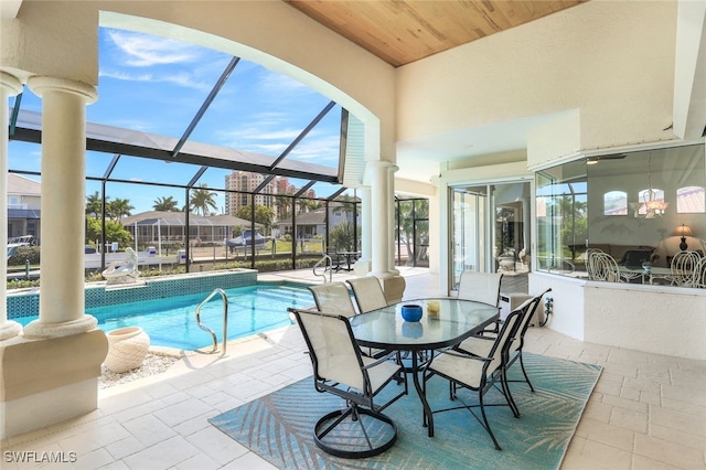 view of swimming pool featuring a patio and glass enclosure