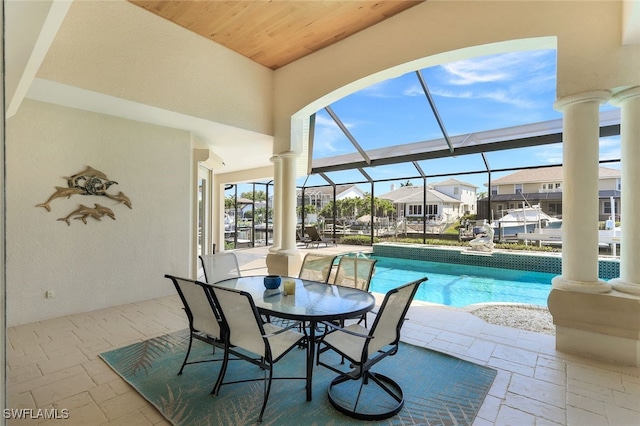 view of swimming pool featuring a patio and glass enclosure