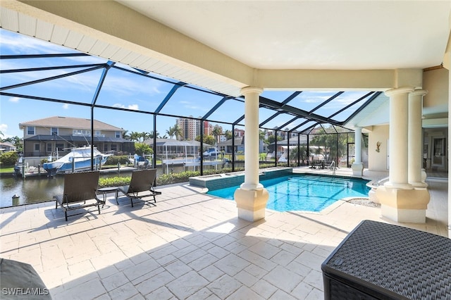 view of pool with a patio, a lanai, and a water view