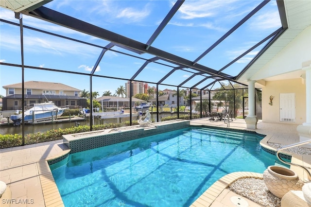 view of pool featuring a water view, a patio area, a lanai, and a dock