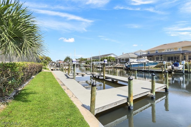 view of dock featuring a water view and a yard