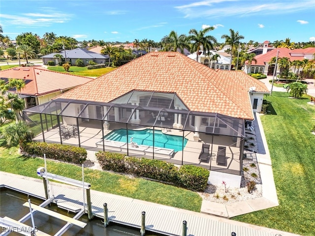 view of pool featuring a patio area, a boat dock, glass enclosure, and a lawn