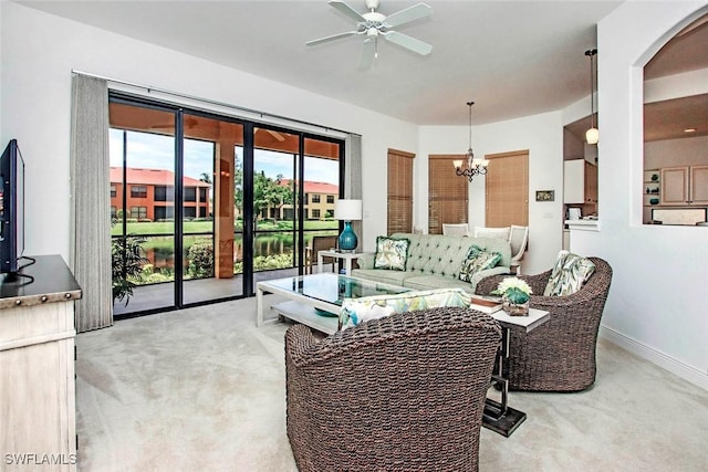 15801 Prentiss Pointe Cir Unit 102, Fort Myers, FL 33908 - living room with light colored carpet, ceiling fan, a chandelier, baseboards, and arched walkways