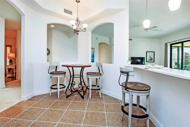 15801 Prentiss Pointe Cir Unit 102, Fort Myers, FL 33908 - kitchen featuring ceiling fan, tile patterned flooring, hanging light fixtures, and arched walkways
