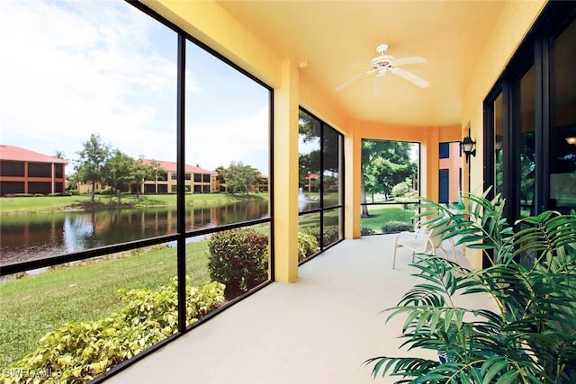 sunroom featuring a water view, plenty of natural light, and ceiling fan