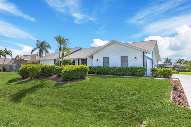 view of front of house featuring a front lawn and a garage