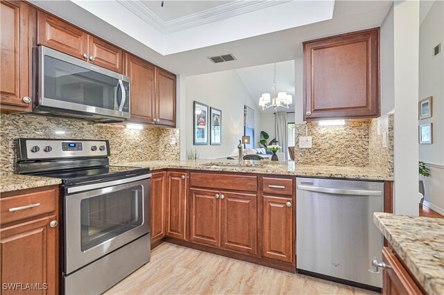 kitchen with ornamental molding, a chandelier, appliances with stainless steel finishes, and tasteful backsplash