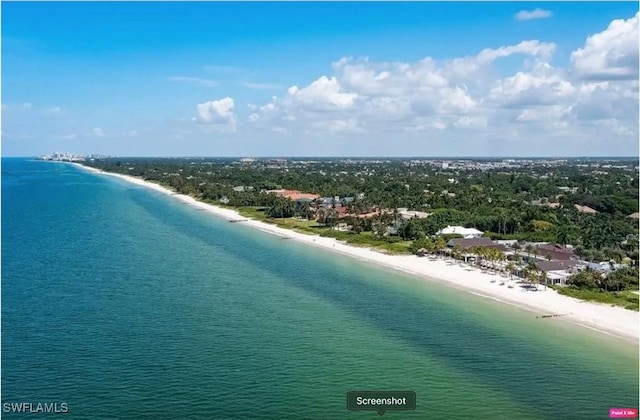 birds eye view of property featuring a water view and a beach view