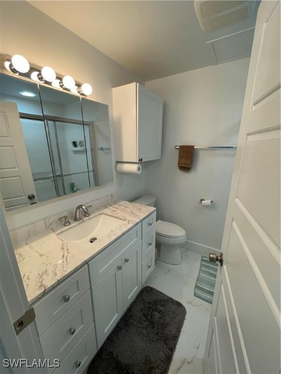 bathroom with a shower with door, vanity, and toilet