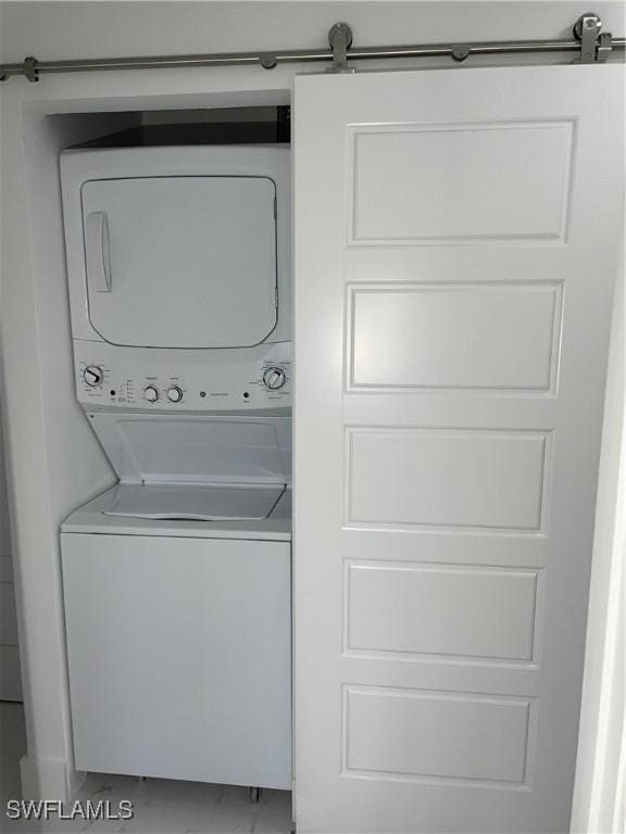 clothes washing area featuring stacked washer and clothes dryer