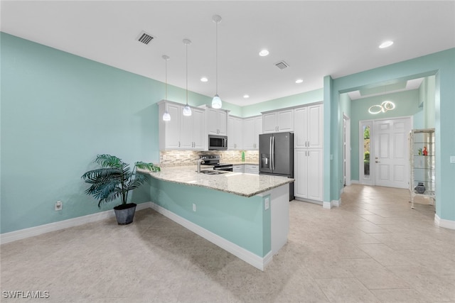 kitchen with appliances with stainless steel finishes, backsplash, kitchen peninsula, hanging light fixtures, and white cabinets