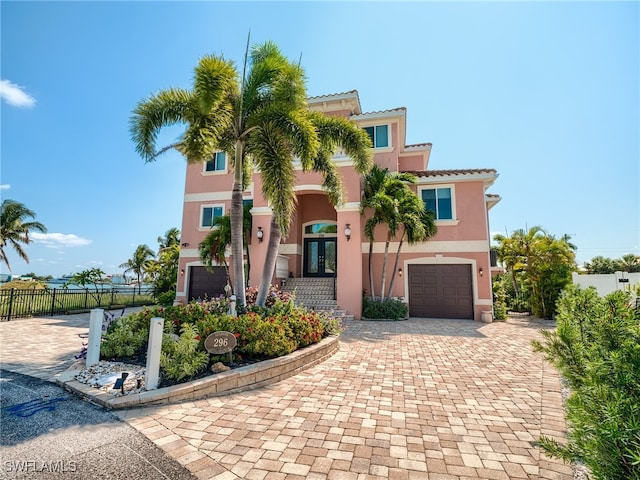 mediterranean / spanish home with a garage and french doors