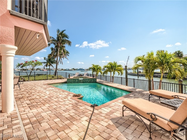 view of pool with a water view, a patio, and an in ground hot tub