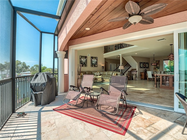 sunroom featuring ornate columns and ceiling fan