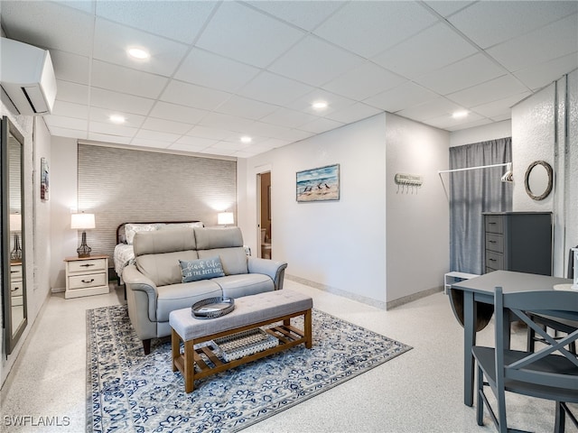 bedroom with a drop ceiling and a wall mounted air conditioner