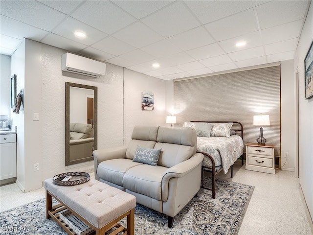 bedroom featuring an AC wall unit and a drop ceiling