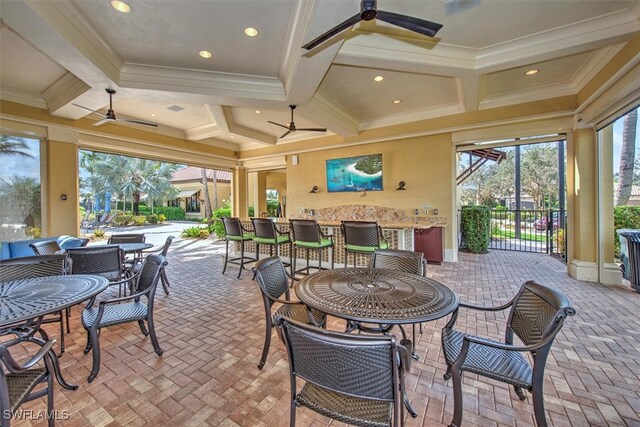 sunroom / solarium featuring coffered ceiling, beamed ceiling, and ceiling fan