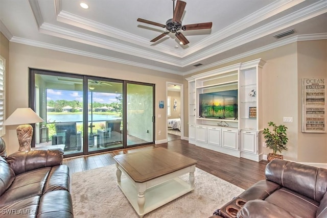 living room with crown molding, dark wood-type flooring, ceiling fan, and a raised ceiling