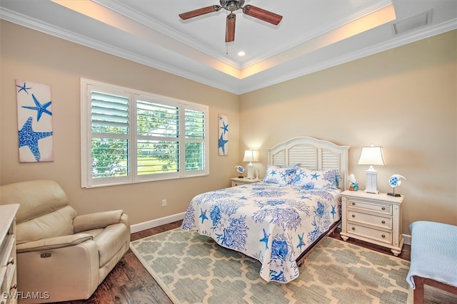 bedroom featuring ceiling fan, a raised ceiling, ornamental molding, and dark wood-type flooring