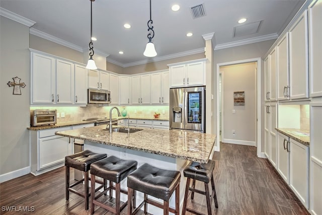 kitchen featuring sink, white cabinetry, decorative light fixtures, and stainless steel appliances