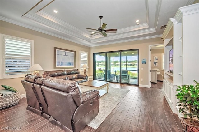 living room with ceiling fan, crown molding, and a tray ceiling