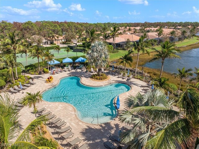 view of swimming pool featuring a patio and a water view