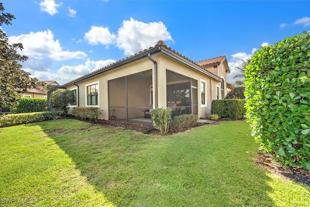 view of property exterior with a yard and a sunroom