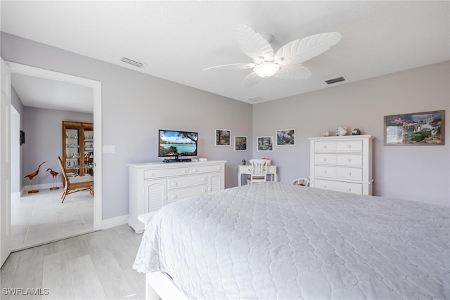 bedroom with light wood-type flooring, visible vents, ceiling fan, and baseboards