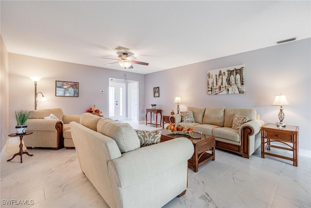 living room featuring marble finish floor, visible vents, ceiling fan, and a textured ceiling