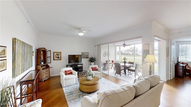 living room featuring wood-type flooring, ornamental molding, and ceiling fan