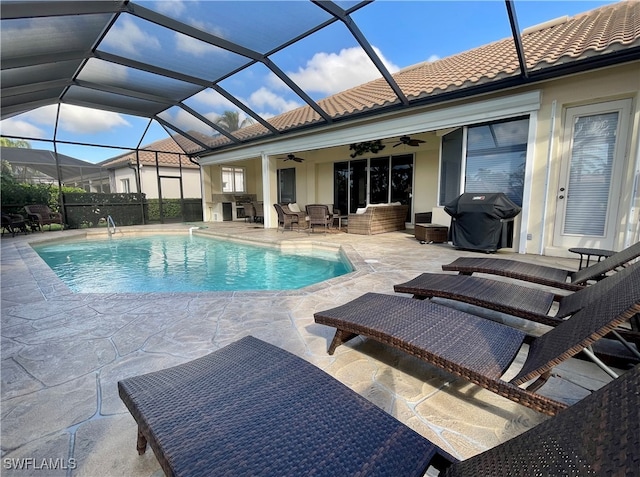 view of swimming pool with ceiling fan, area for grilling, a patio, and glass enclosure