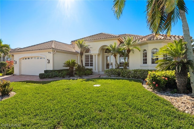 mediterranean / spanish-style house with a front yard and a garage