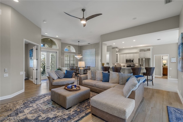 living room featuring french doors, light hardwood / wood-style flooring, and ceiling fan