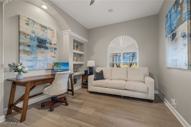 office space featuring built in shelves and light hardwood / wood-style flooring