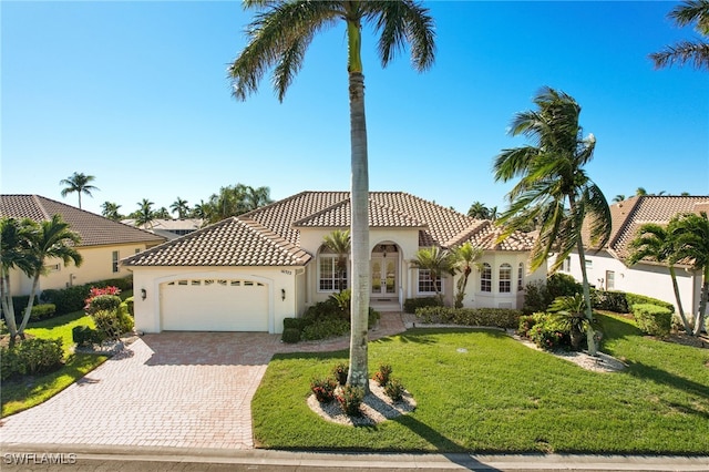 mediterranean / spanish-style home featuring a garage and a front yard