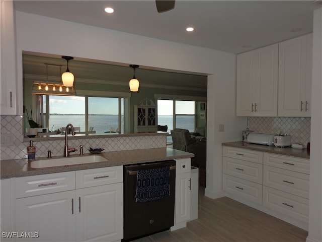 kitchen with dishwasher, sink, hardwood / wood-style floors, decorative light fixtures, and a water view