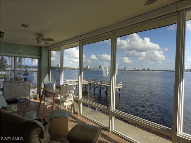 sunroom / solarium with a water view and ceiling fan