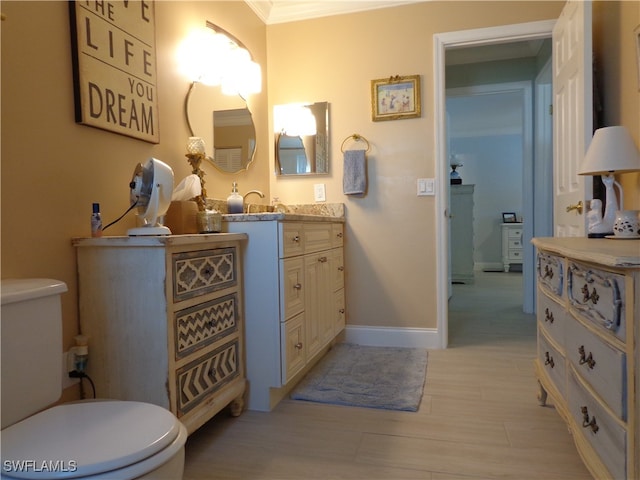 bathroom featuring vanity, ornamental molding, and toilet