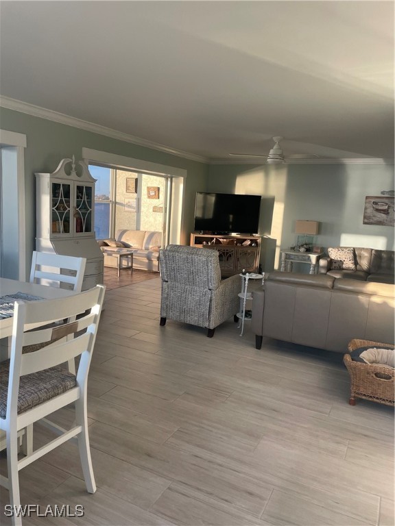 living room with crown molding and ceiling fan