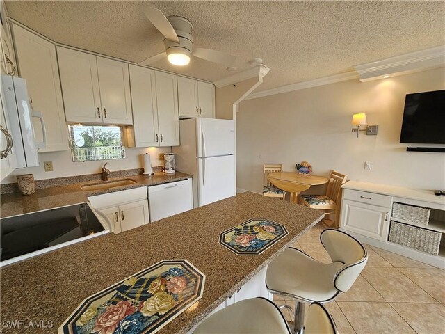 kitchen featuring sink, crown molding, light tile patterned floors, white appliances, and white cabinets